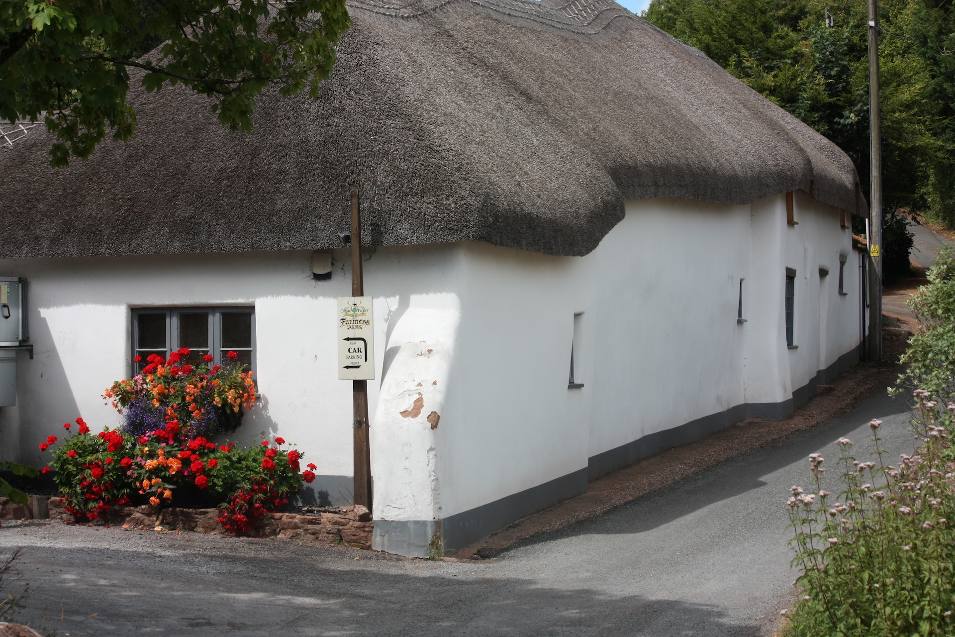 The exterior of a white-washed thatched village pub in the Quantock Hills