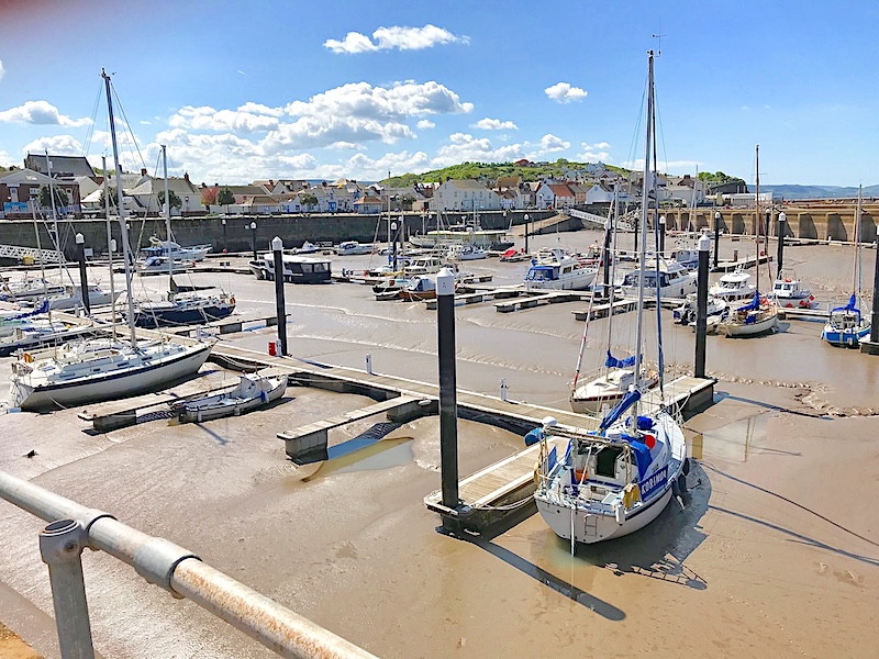watchet harbour at low tide..Small fishing boats and yachts are settled on the sandy harbour floor.