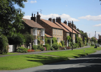 A row of stone-built cottages overlook a village green in Sutton-on-the-Forest