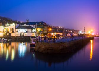 Falmouth Quay illuminations reflect on the water after dark,