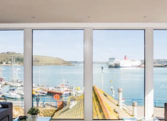 Falmouth harbour from a lounge with floor-to-ceiling windows.