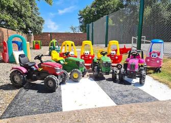 A collection of childs pedal cars modelled as tractors.