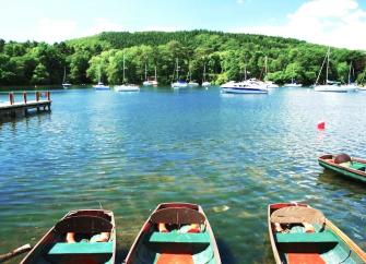 Rowing boats for hire waiting for custom moored to a jetty on Coniston Water.