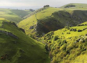 An aerial of Peak District hills and valleys.