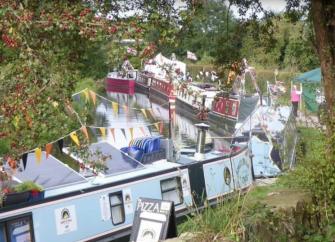 Brightly painted narrow boats line the towpath at a Shropshire Canal Festival.