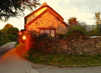 An autumn sunset lights up the stone walls of a North Devon holiday cottage