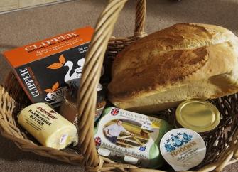 Edible contents of a welcome pack in a pannier basket at a Benoy Holiday Cottage in Dorset