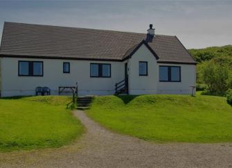 A secluded holiday bungalow surrounded by lawns in the Scottish countryside.