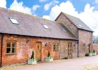 A brick-built barn conversion overlooks a block-paved courtyard in Shropshire.