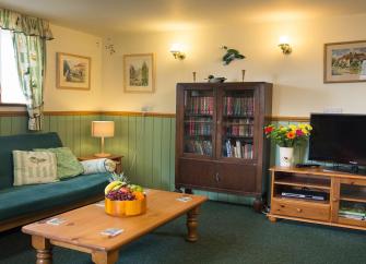 A holiday cottage lounge with sofa, coffee table and wide-screen tv.