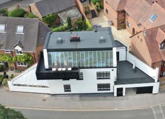 A contemporary 1st floor apartment with an entire wall of floor-to-ceiling glass windows and wrap around balcony. 