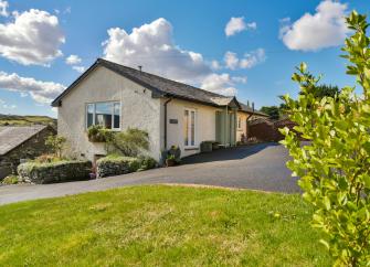 A Coniston holiday bungalow with a lawn and large tarmac space for guest's cars