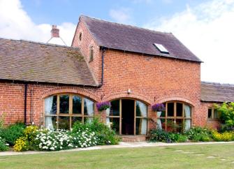 A two-storey Shropshire barn conversion with arched floor-to-ceiling ground floor windows.