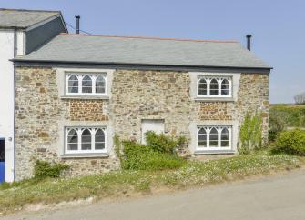 A double fronted stone-built North Devon country cottage with arched windows