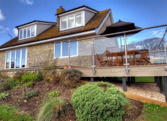 A large multi-windowed chalet bungalow in Charmouth with an extended plate-glass walled deck