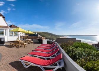 A 2-storey holiday cottage with a large sun terrace overlooks a sandy beach.