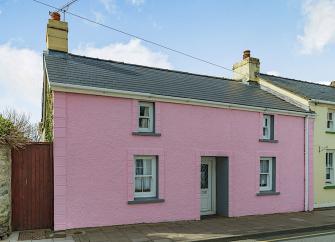 A double-fronted Pembrokeshire holiday cottage overlooks a quiet lane.