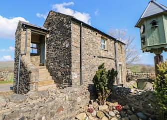 Exterio of a barn conversion with steps to 1st lfoor entrance, in a moorland location.