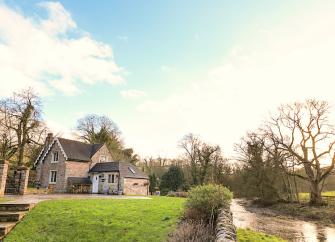 A stone-built riverside cottage in Derbyshire overlook. large lawn.