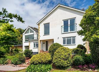 A large 2-storey Teignmouth holiday home overlooks a shrub-filled garden.