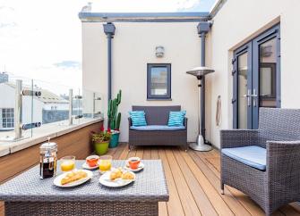 A Weymouth apartment deck with a table laid for breakfast.