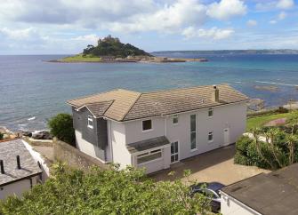 A large contemporary holiday home overlooks a beach and St. Michaels Mount in Cornwall