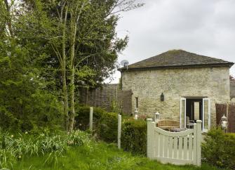 A stone-built barn conversion with a garden protected by a low hedge.