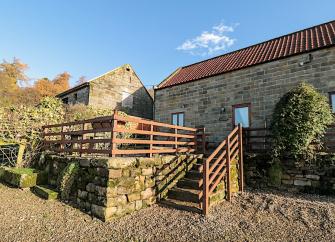 Stone-built, barn conversion exterior with a raised, secure BBQ terrace.