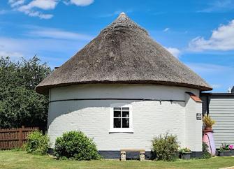 Circular exterior of cottage created within the base of a Suffolk windmill