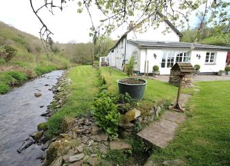 A North Devon riverside cottage with a large lawn.
