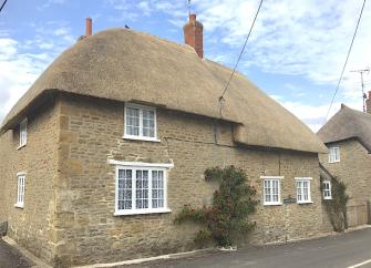 A 2-storey, thatched Dorset holiday cottage on a quiet village street.