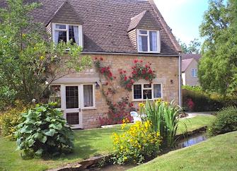 A 2-storey stone-built Cotswold mill conversion overlooking a well-kept garden.