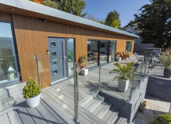 Exterior of a luxury Minehead lodge with bi-fold glass dors and a spacious deck.o