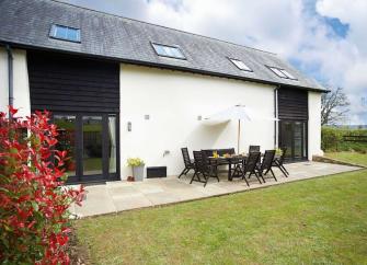 A large single storey barn with a private, secure, hedge-lined lawn.