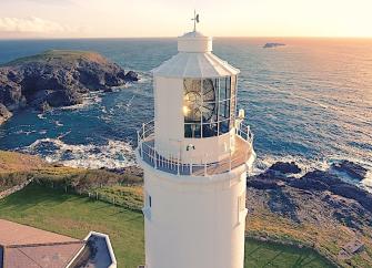 A lighthouse tower overlooks the rugged North Cornwall coastline.