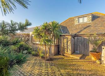 2-storey, clapper-board lodge overlooks a courtyard ringed by a secure wall.