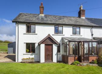 Semi-detached Exmoor country cottage with conservatory and lawned garden.