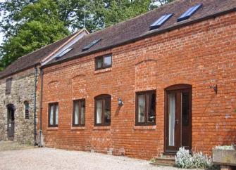 Exterior of a brick-built Shropshire barn conversion with a courtyard.