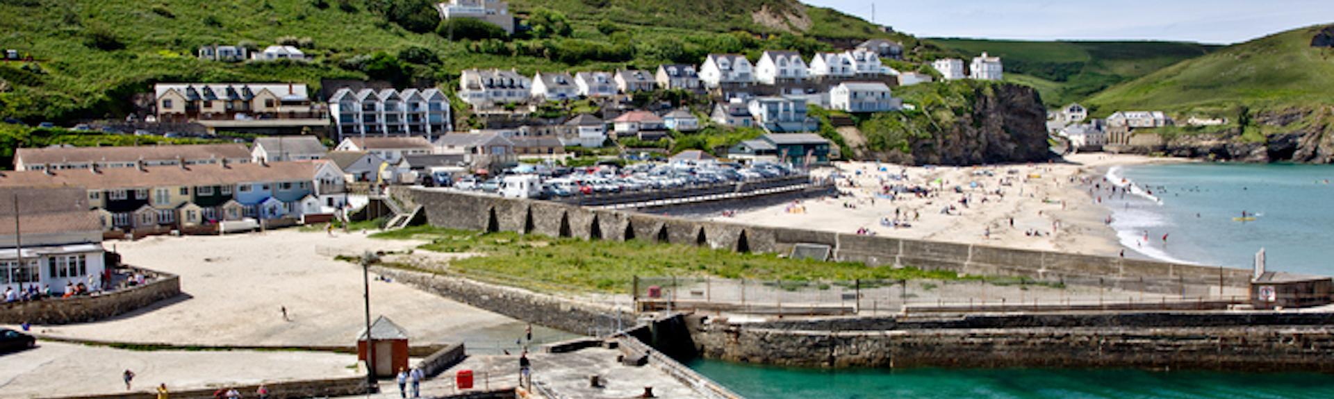 A view of the Harbour at Portreath with the beach and village beyond.
