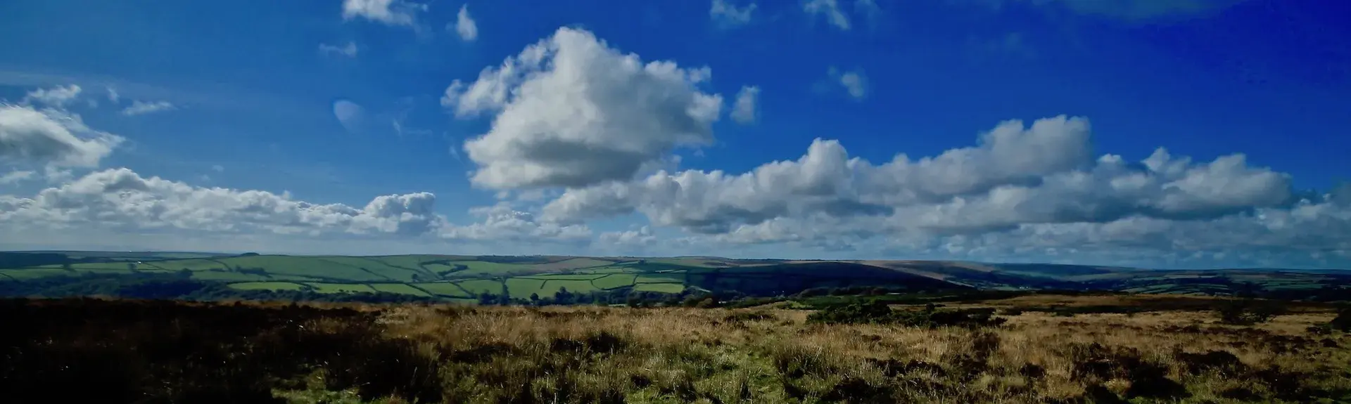 Rows of cumulous clouds float above Exmoor across open moorland.