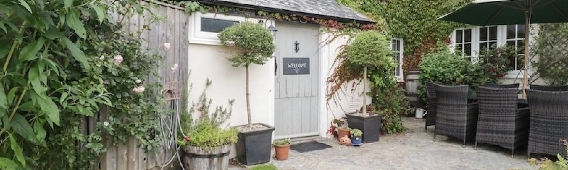 A farmhouse overlooks a garden courtyard.