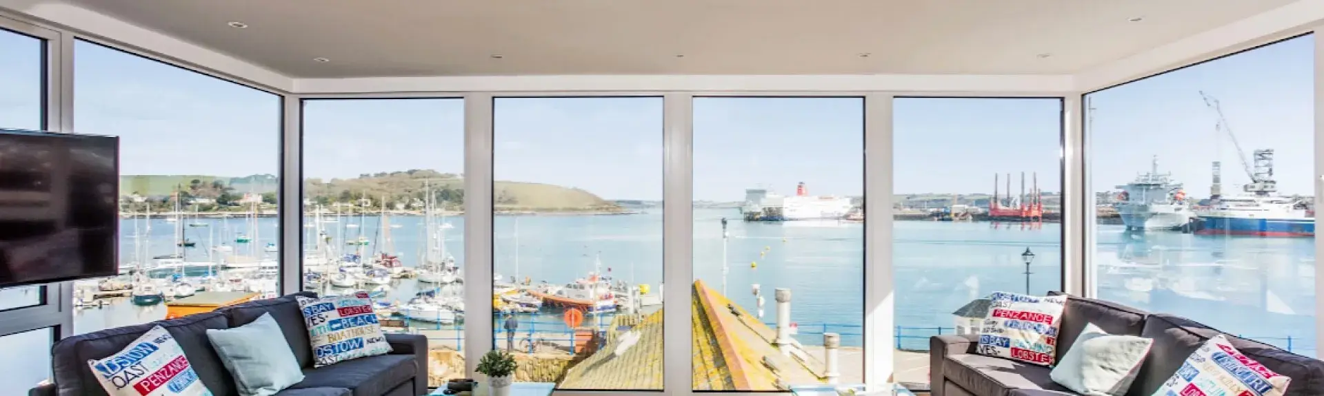 Falmouth harbour from a lounge with floor-to-ceiling windows.