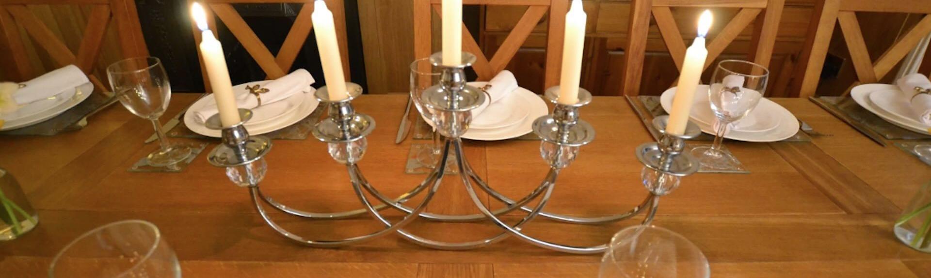 5 brightly burning candles on a table candelabra.