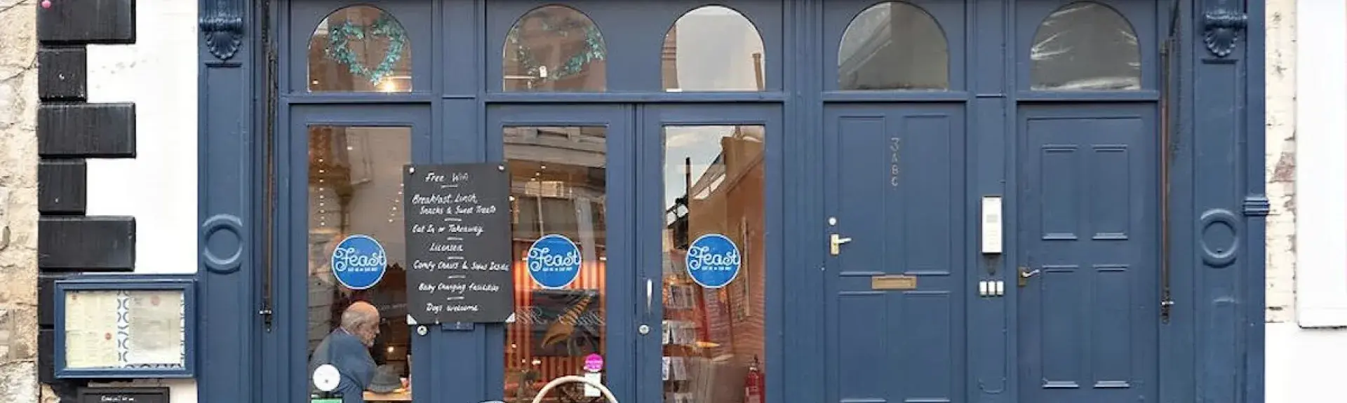 Feast cafe shop front in Pickering with large windows through which tables and chair can be seen