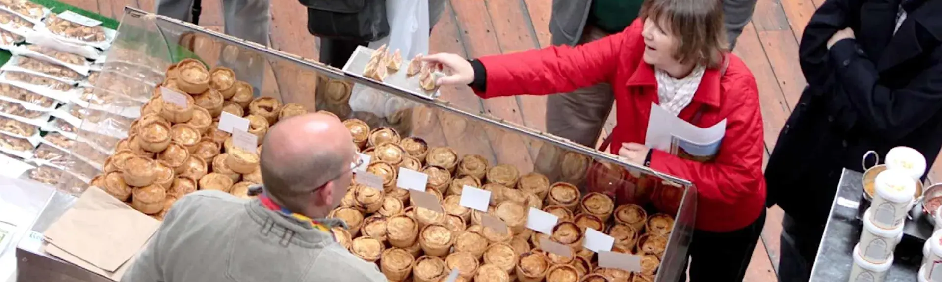 A woman buys pies in a Peak District Farmers Market.