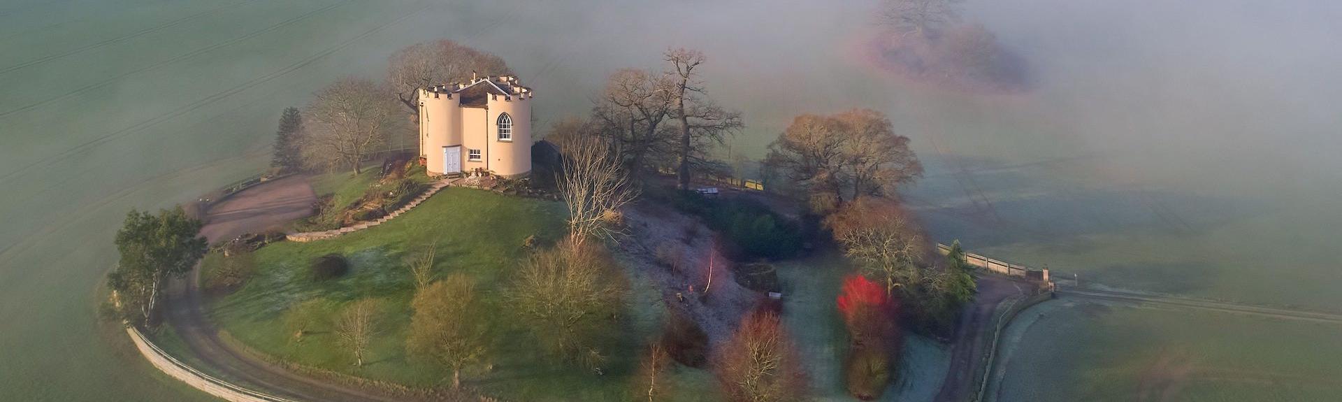 Aerial view of Sham Castle, a Victorian folly shrouded in mist.