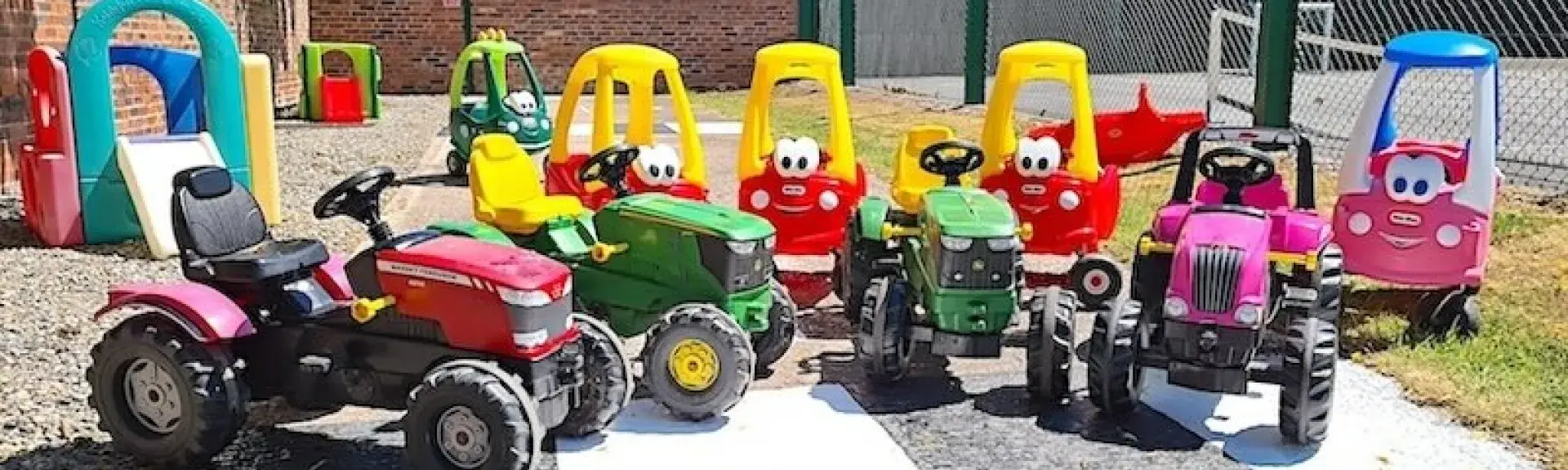 A collection of childs pedal cars modelled as tractors.