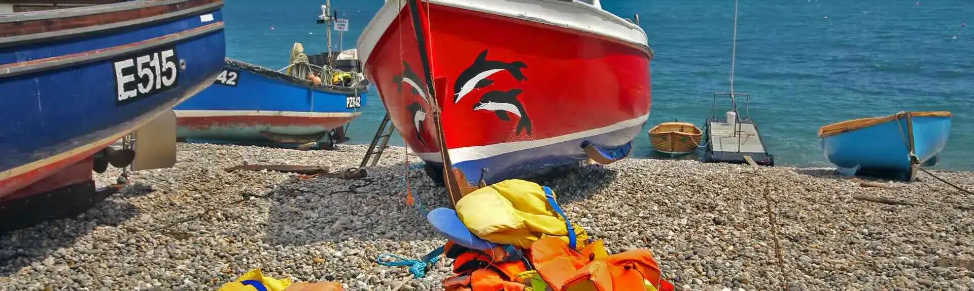 Inshore fishing boats and gear moored on a shingle beach.