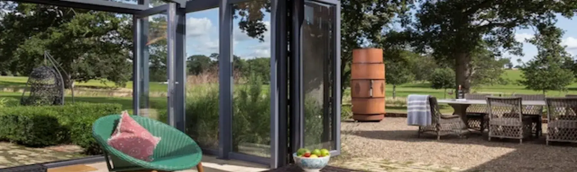 A contemporary conservatory with bi-fold French windows opening on to a garden patio.