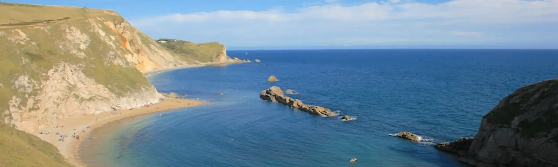 Lulworth Cove: a circular sandy beach backed by cliffs.